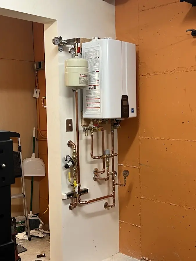 Plumbing technician inspecting water heater connections in Putnam